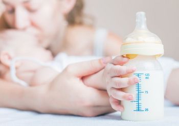 Mama z dzieckiem i butelką z mlekiem