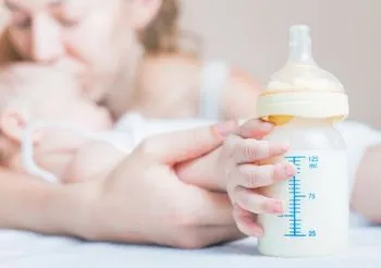 Mama z dzieckiem i butelką z mlekiem