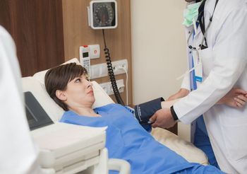 lekarz zakłada ciśnieniomierz na ramię pacjentki