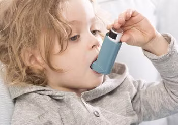 Dziceko z astmą używa inhalatora