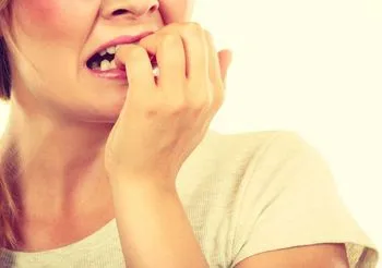 Zestresowana dziewczyna obgryza paznokci