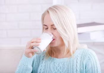 Starsza kobieta pije kefir
