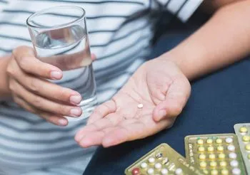 Kobieta połyka pigułkę