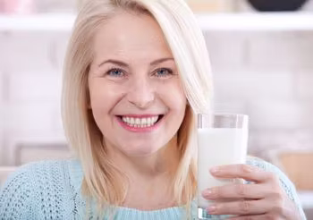 Kobieta w średnim wieku pijąca kefir