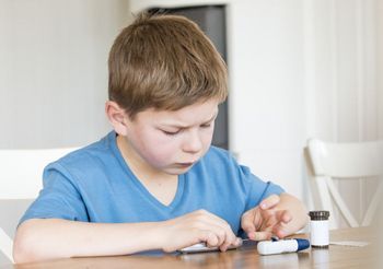 Mały chłopiec sprawdza poziom cukru