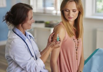 Lekarka robi kobiecie szczepionkę