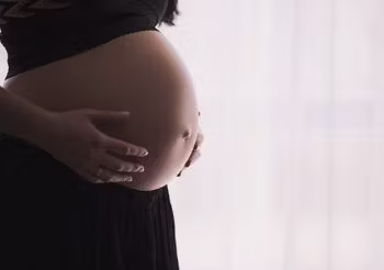 kobieta w ciąży z odsłoniętym brzuchem