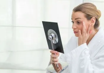 Dziewczyna w szlafroku przegląda się w lusterku