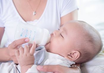 Mama karmi niemowlę butelką