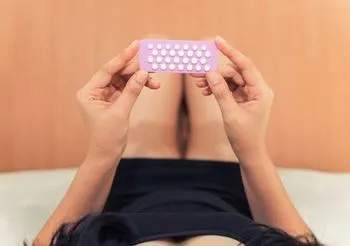 Dziewczyna trzyma tabletki antykoncepcyjne