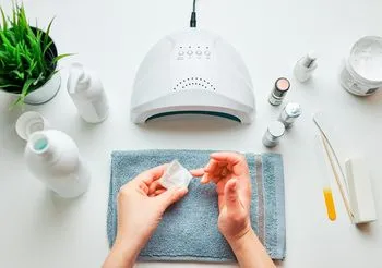 Uczulenie na hybrydę mogą wywołać zarówno składniki lakierów używanych podczas manicure, jak i naświetlanie dłoni lampą UV. Fot. Adobe Stock.