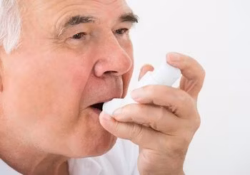 starszy mężczyzna używa inhalatora