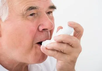 starszy mężczyzna używa inhalatora