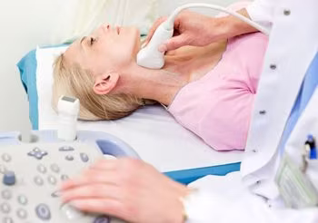 Lekarz za pomocą usg bada kobiecie szyję