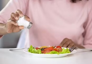 Młoda kobieta dosala swoją sałatkę 