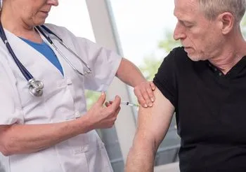 Lekarka robi mężczyźnie szczepionkę