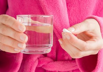 Kobieta popija pigułkę wodą