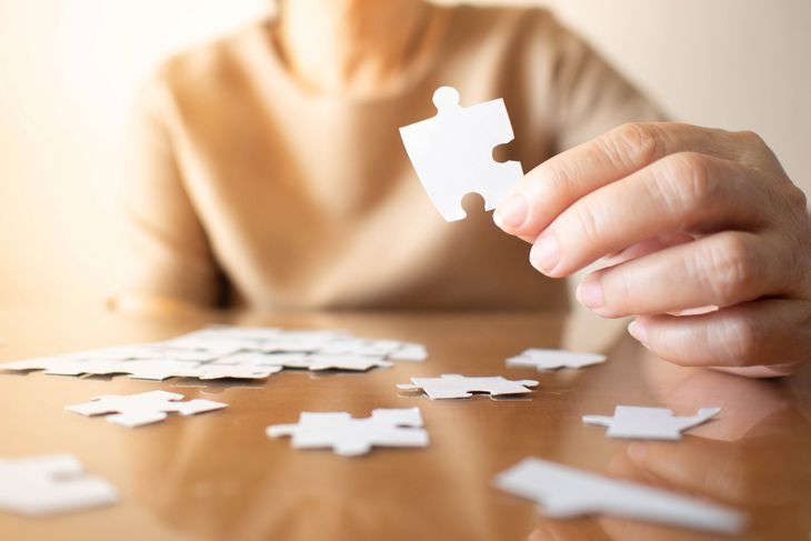 Starsza kobieta układa puzzle