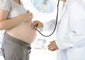 lekarz bada ciężarną kobietę