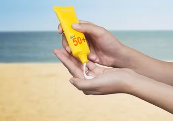 kobieta nakłada na dłoń krem z filtrem