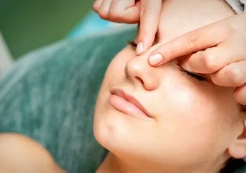 Domowy sposób na zatoki to masowanie zatok. Uciskanie czoła, masaż oczodołów usprawnia krążenie krwi oraz limfy. Fot. Adobe Stock.