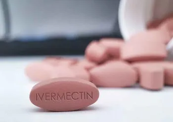 Iwermektyna w postaci różowej tabletki na stole. 