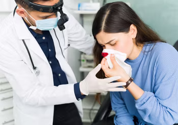 Pierwsza pomoc przy krwotoku z nosa polega przede wszystkim na uspokojeniu poszkodowanego. Krwawiący powinien usiąść, pochylając się lekko do przodu.