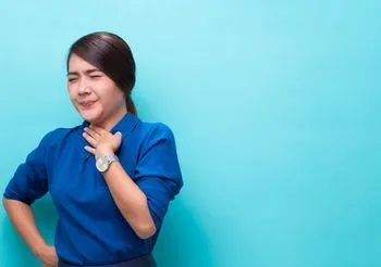 Młoda kobieta trzymająca dłon na tarczycy