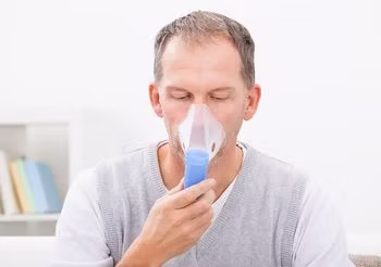 Mężczyzna w średnim wieku podczas nebulizacji. 