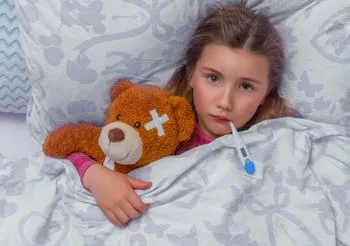 Dziewczyna z gorączką przytula misia