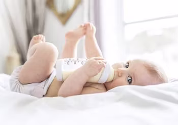 Dziewczynka pije mleko z butelki