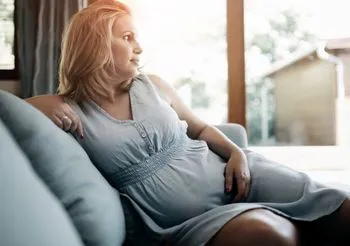 Kobieta w ciąży odpoczywa na kanapie