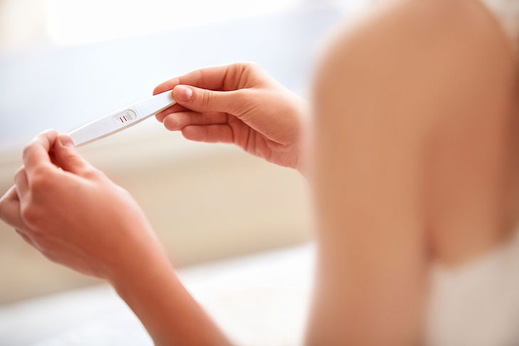 Kobieta trzymająca w dłoniach test ciążowy 