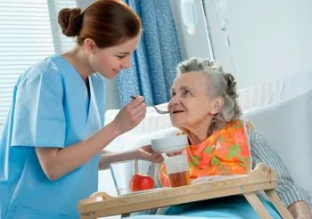 Starsza pacjentka karmiona przez pielęgniarkę 
