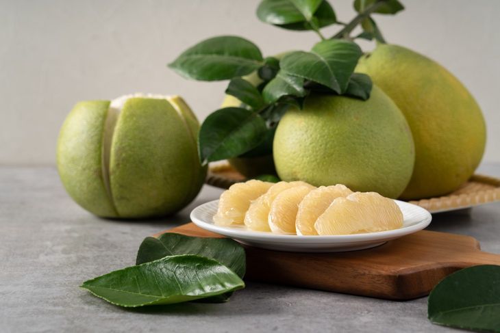 Pomelo do jedzenia obiera się ze skóry i białej błonki i dzieli na cząstki. Fot. Adobe Stock.