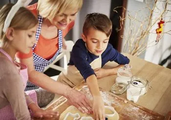 kobieta z dwójką dzieci przygotowuje wypieki