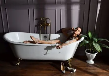 Młoda kobieta leży w kąpieli w wannie