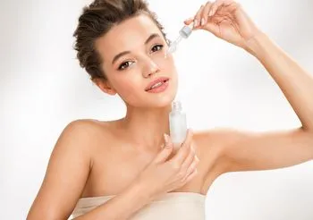 Kobieta trzymająca buteleczkę z pipetką