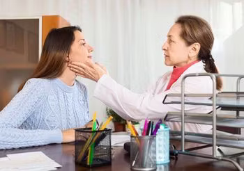 Pacjentka w gabinecie podczas badania fizykalnego tarczycy 
