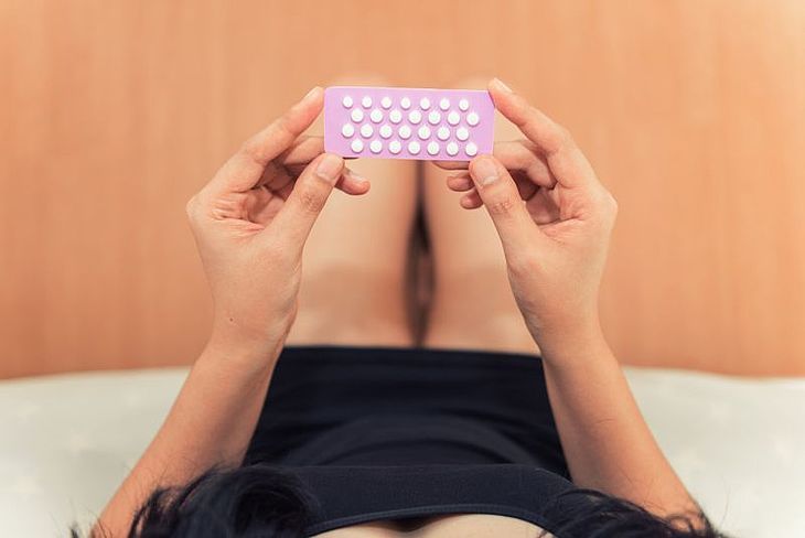 Dziewczyna trzyma tabletki antykoncepcyjne